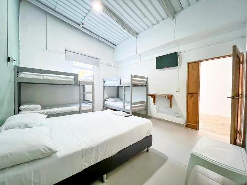 a bedroom with two bunk beds and a tv at Hotel Palma Grande by Stanza in Coveñas