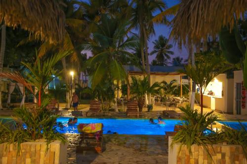 a resort pool with people swimming in it at night at Hotel Palma Grande by Stanza in Coveñas
