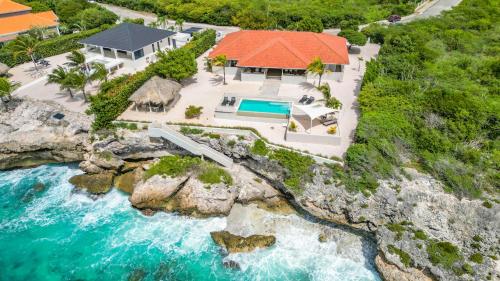 an aerial view of a house next to the water at Coral Estate Holidays in Willibrordus