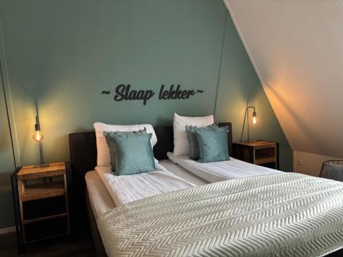 a bedroom with two beds and a sign on the wall at Prachtige vakantievilla Burdaard in Burdaard