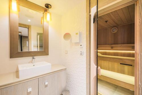 uma casa de banho com um lavatório e um espelho em Résidence Premium L'Hévana - maeva Home - Appartement 4 pièces 8 personnes 47 em Les Allues