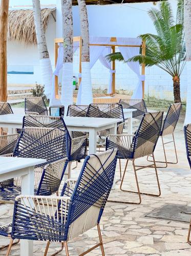a group of chairs and tables on the beach at Hotel Palma Grande by Stanza in Coveñas