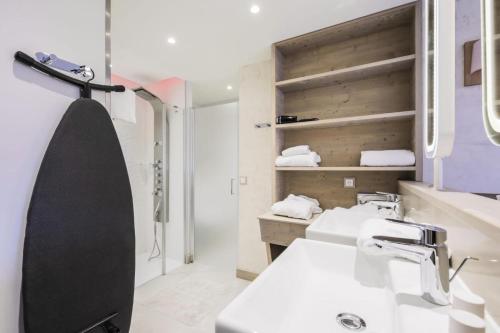La salle de bains est pourvue d'un lavabo et d'une douche. dans l'établissement Résidence Premium L'Hévana - maeva Home - Appartement 3 pièces 6 personnes 94, à Les Allues