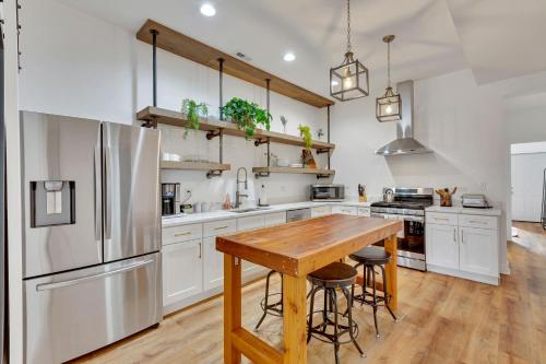 eine Küche mit einem Holztisch und einem Kühlschrank in der Unterkunft Bright Modern 4Bd 2Ba in the Heart of Wrigleyville condo in Chicago