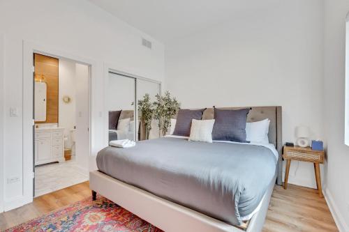 a white bedroom with a large bed with blue pillows at Bright Modern 4Bd 2Ba in the Heart of Wrigleyville condo in Chicago