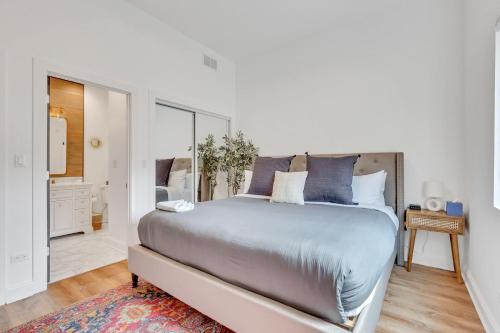 a white bedroom with a large bed with blue pillows at Bright Modern 4Bd 2Ba in the Heart of Wrigleyville condo in Chicago