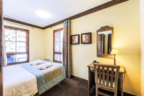 - une chambre avec un lit et un bureau avec un miroir dans l'établissement Résidence Les Arcs 1950 Le Village - maeva Home - Appartement 3 pièces 6 personnes Sélection MAE-2661, à Bourg-Saint-Maurice