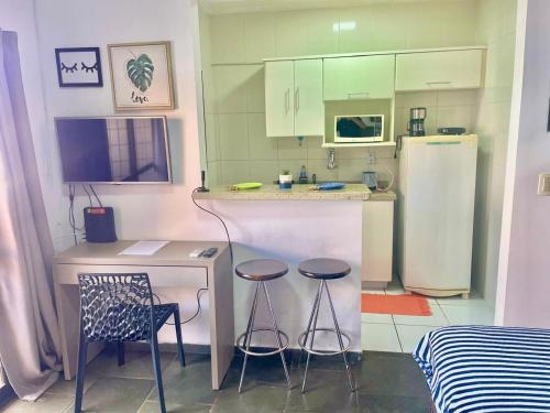 a kitchen with two stools and a counter with a refrigerator at RAVENA 11 in Ribeirão Preto