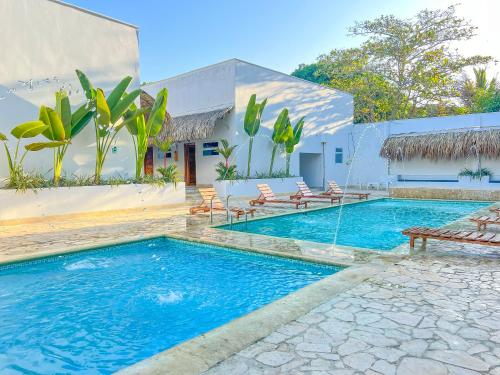 a swimming pool in front of a house at Hotel Palma Grande by Stanza in Coveñas