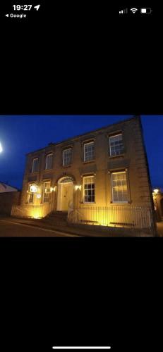 a large brick building with lights on it at night at Ashmore House Cashel in Cashel
