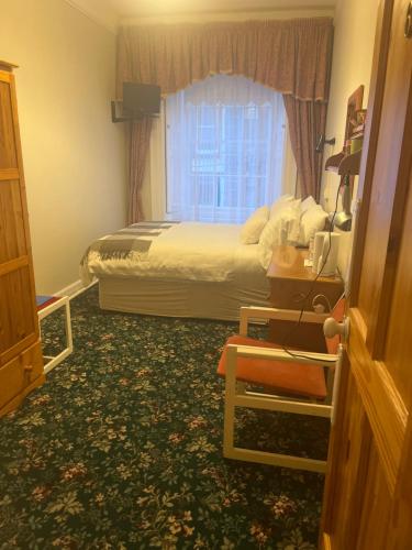 a hotel room with a bed and a window at Ashmore House Cashel in Cashel