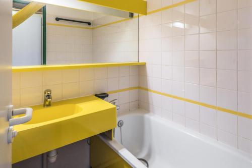 a bathroom with a yellow sink and a bath tub at Résidence Quartier Falaise - maeva Home - Appartement 2 Pièces 4 Personnes - Sélection MAE-4227 in Avoriaz