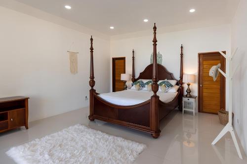 a bedroom with a canopy bed and a rug at Blue Elephant Villa Koh Phangan in Haad Pleayleam