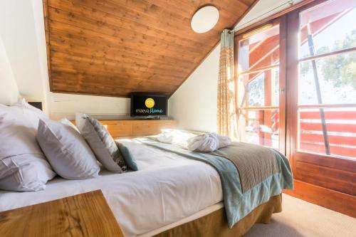 a bedroom with a large bed with a large window at Résidence Les Arcs 1950 Le Village - maeva Home - Appartement 3 pièces 6 personnes vue sur le Mont Blanc - Prestige - super Home MAE-4490 in Bourg-Saint-Maurice