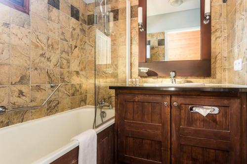 a bathroom with a tub and a sink and a bath tub at Résidence Les Arcs 1950 Le Village - maeva Home - Appartement 3 pièces 6 personnes vue sur le Mont Blanc - Prestige - super Home MAE-4490 in Bourg-Saint-Maurice