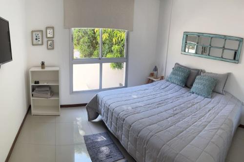 1 dormitorio con cama grande y ventana grande en Hermoso departamento en Villa Morra, en Asunción