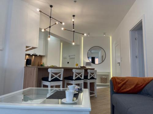 a living room and kitchen with a table and a couch at Apartament Komfort Promenada Ełk in Ełk