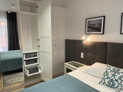 a small bedroom with a bed and a mirror at Apartament Komfort Promenada Ełk in Ełk