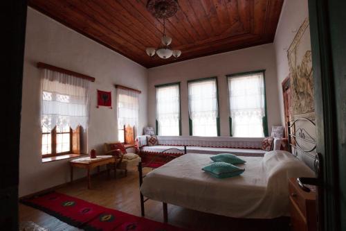 - une chambre avec un lit, un canapé et des fenêtres dans l'établissement GuestHouse 1805, à Gjirokastër