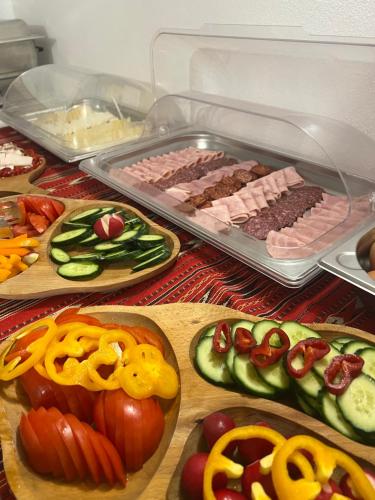 a table topped with different types of meats and vegetables at Hotel PrincesSophie in Sighişoara