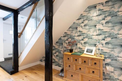 a room with a stone wall with a wooden dresser at FORD GATE - Modern Luxury Cottage based in Holmfirth in Holmfirth