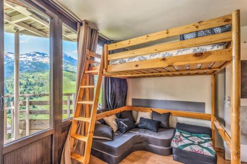 Ce lit superposé se trouve dans un dortoir doté d'un canapé et d'une échelle. dans l'établissement Résidence Les Ruches - maeva Home - Studio 3 Personnes - Confort - Bâtiment Vivace MAE-6759, à Avoriaz