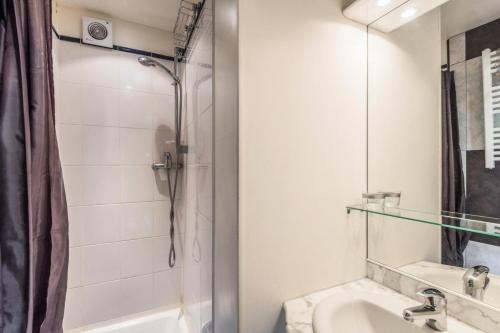 une salle de bain blanche avec une douche et un lavabo dans l'établissement Résidence Les Ruches - maeva Home - Studio 3 Personnes - Confort - Bâtiment Vivace MAE-6759, à Avoriaz