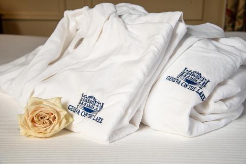 two towels sitting on top of a bed with a rose at Geneva On The Lake Boutique Resort Hotel in Geneva
