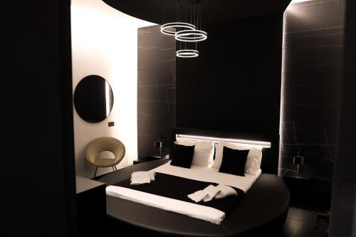 czarno-biała sypialnia z łóżkiem z poduszkami w obiekcie 115 Luxury Suite - Privitera w mieście Grammichele