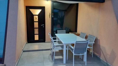 a table and chairs on a balcony with a door at Apartmani Delas 2 in Pješčana Uvala 