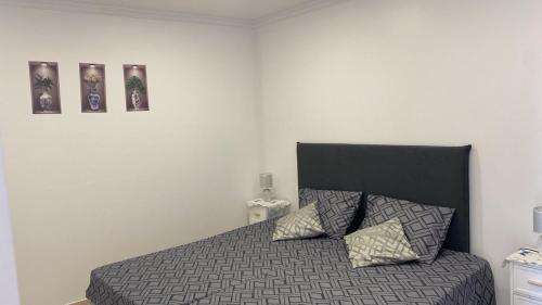 a bedroom with a bed with two pictures on the wall at SLICE OF PONTA DO SOL- GROUND FLOOR- SEA VIEW in Ponta do Sol
