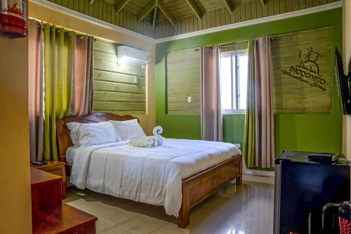 a bedroom with a bed with green walls and a window at Incognito Culture Rooms in Kingston