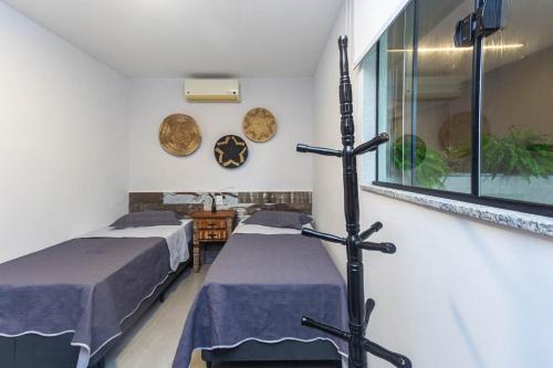 um quarto de hospital com duas camas e uma janela em Pê na areia Loft Praia de Itaipú em Itaipu