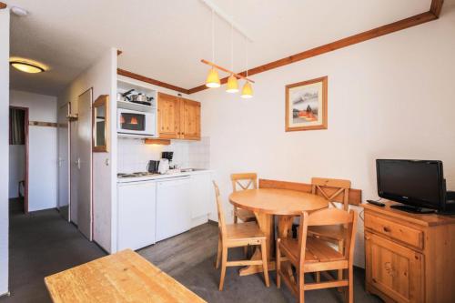 une cuisine et une salle à manger avec une table et une télévision dans l'établissement Résidence Les Horizons d'Huez - maeva Home - Appartement 2 pièces 5 personnes Confort MAE-7180, à Huez