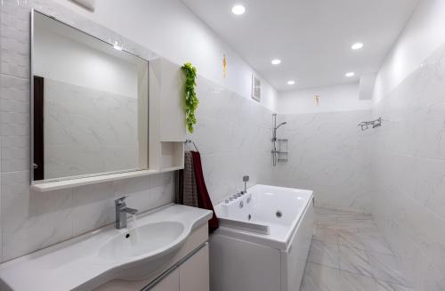 a white bathroom with a sink and a mirror at Blue Elephant Villa Koh Phangan in Haad Pleayleam