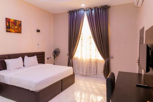 ein Schlafzimmer mit einem Bett und einem großen Fenster in der Unterkunft Yona Resort Inn in Ijebu Ode
