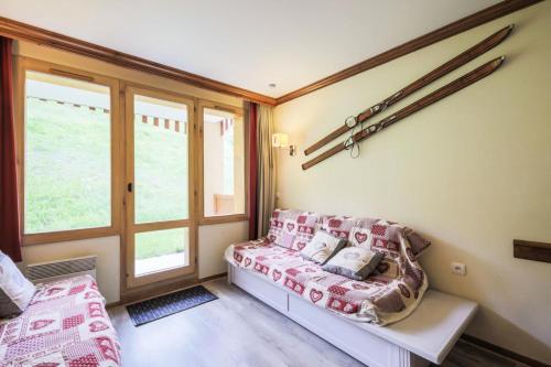 un salon avec un canapé et une fenêtre dans l'établissement Résidence La Marelle et Le Rami - maeva Home - Appartement 2 pièces 5 personnes Sélection MAE-9115, à La Plagne Tarentaise