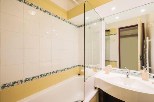 une salle de bain avec une baignoire, un lavabo et un miroir dans l'établissement Résidence La Marelle et Le Rami - maeva Home - Appartement 2 pièces 5 personnes Sélection MAE-9115, à La Plagne Tarentaise