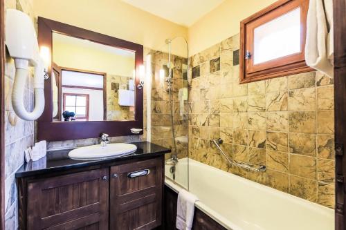 une salle de bain avec un lavabo et une baignoire dans l'établissement Résidence Les Arcs 1950 Le Village - maeva Home - Appartement 3 Pièces 6 Personnes - Sélection MAE-2357, à Bourg-Saint-Maurice