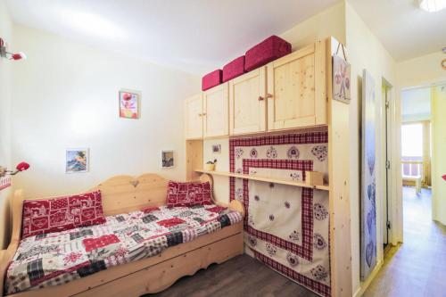 - une chambre avec un lit en bois et des oreillers rouges dans l'établissement Résidence Le Sextant - maeva Home - Studio 4 Personnes - Confort MAE-7964, à La Plagne Tarentaise