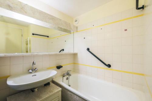 une salle de bain avec un lavabo et une baignoire dans l'établissement Résidence Le Sextant - maeva Home - Studio 4 Personnes - Confort MAE-7964, à La Plagne Tarentaise