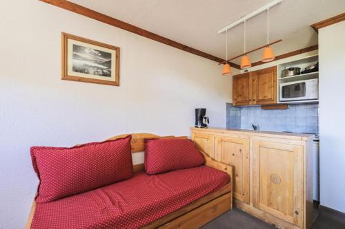 - un canapé rouge dans une chambre avec cuisine dans l'établissement Résidence Les Horizons d'Huez - maeva Home - Studio 5 personnes - Confort MAE-2572, à Huez