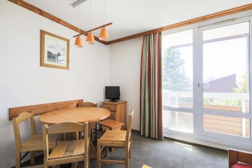 une salle à manger avec une table et des chaises et une fenêtre dans l'établissement Résidence Les Horizons d'Huez - maeva Home - Studio 5 personnes - Confort MAE-2573, à Huez