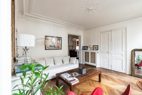 un salon avec un canapé blanc et une table dans l'établissement Appartement Guersant - Welkeys, à Paris