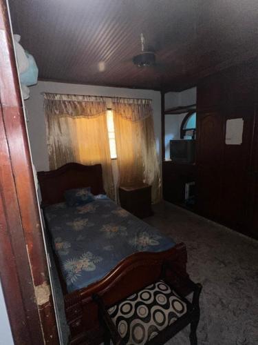 ein Schlafzimmer mit einem Bett und einem Stuhl darin in der Unterkunft Habitación individual festival in Valledupar