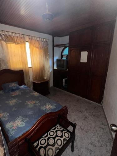 um quarto com uma cama e uma cadeira em Habitación individual festival em Valledupar