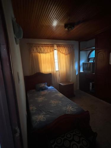 een slaapkamer met een bed in een kamer met een raam bij Habitación individual festival in Valledupar
