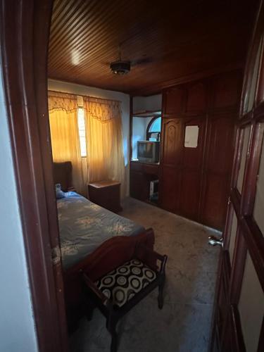 1 dormitorio con 1 cama y 1 silla en Habitación individual festival en Valledupar