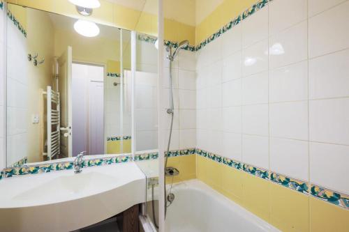 une salle de bain avec une baignoire, un lavabo et un miroir dans l'établissement Résidence Le Thabor - maeva Home - Appartement 2 Pièces 5 Personnes - Confort MAE-2620, à Le Désert