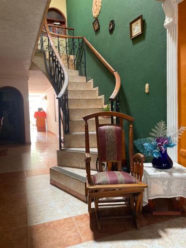 a living room with a rocking chair and stairs at Habitación individual festival in Valledupar